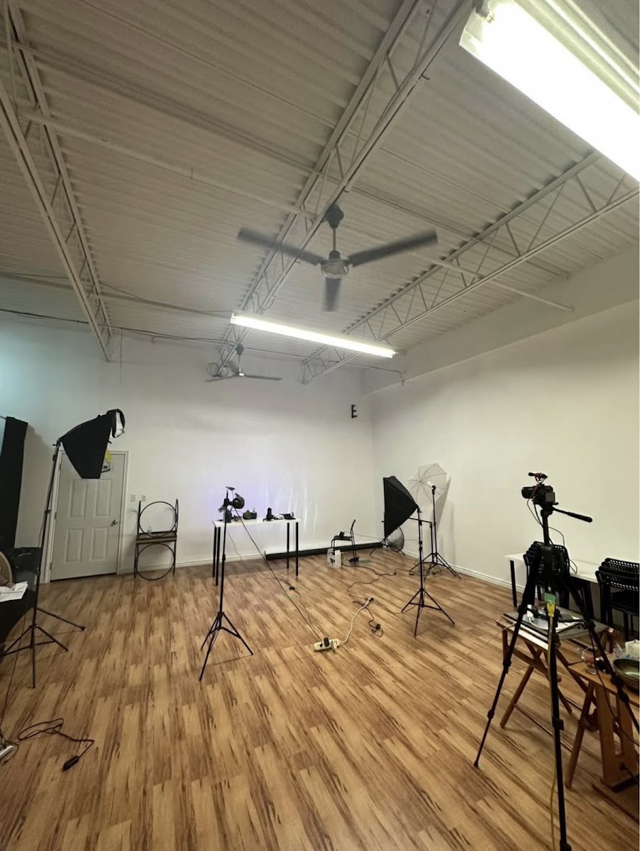 Media Factory Group studio — wide shot with professional lighting equipment and hardwood floors